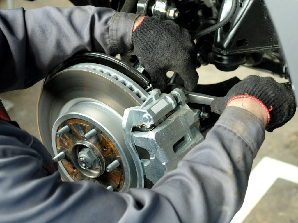 Close-up of brake disc, pads, and caliper during a brake repair in Tacoma
